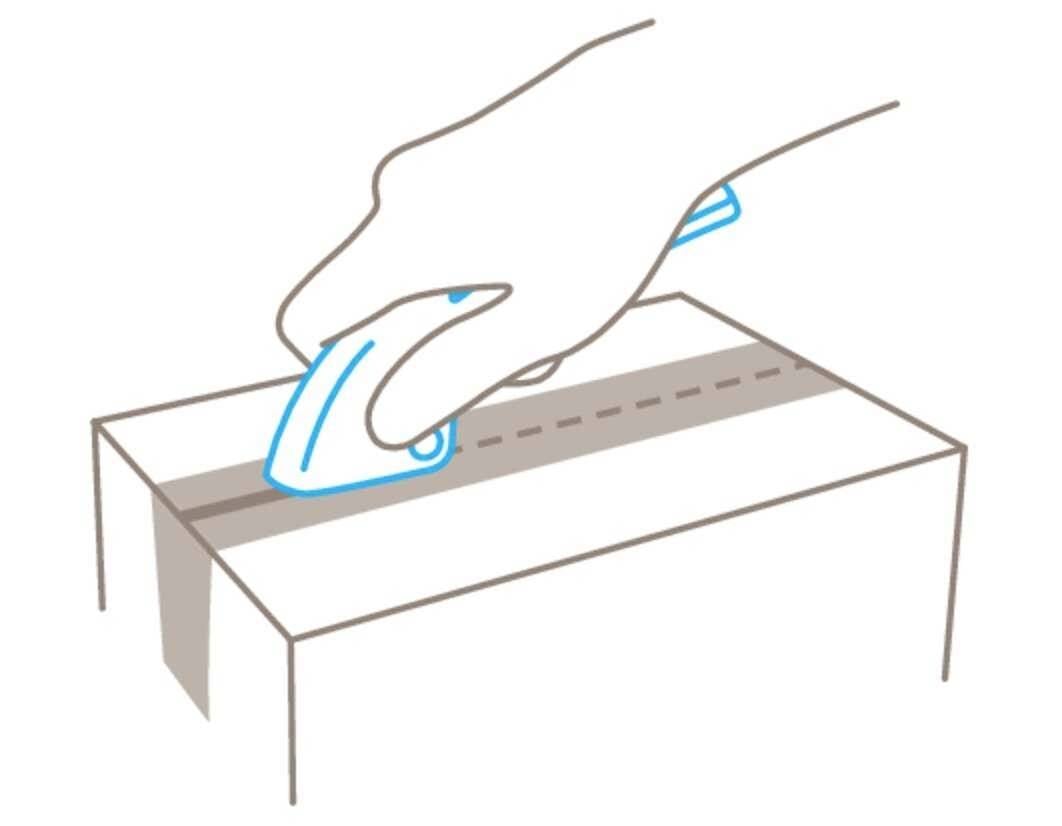 Eine Hand verwendet einen Kartonschneider, um einen Karton entlang der Naht zu öffnen.