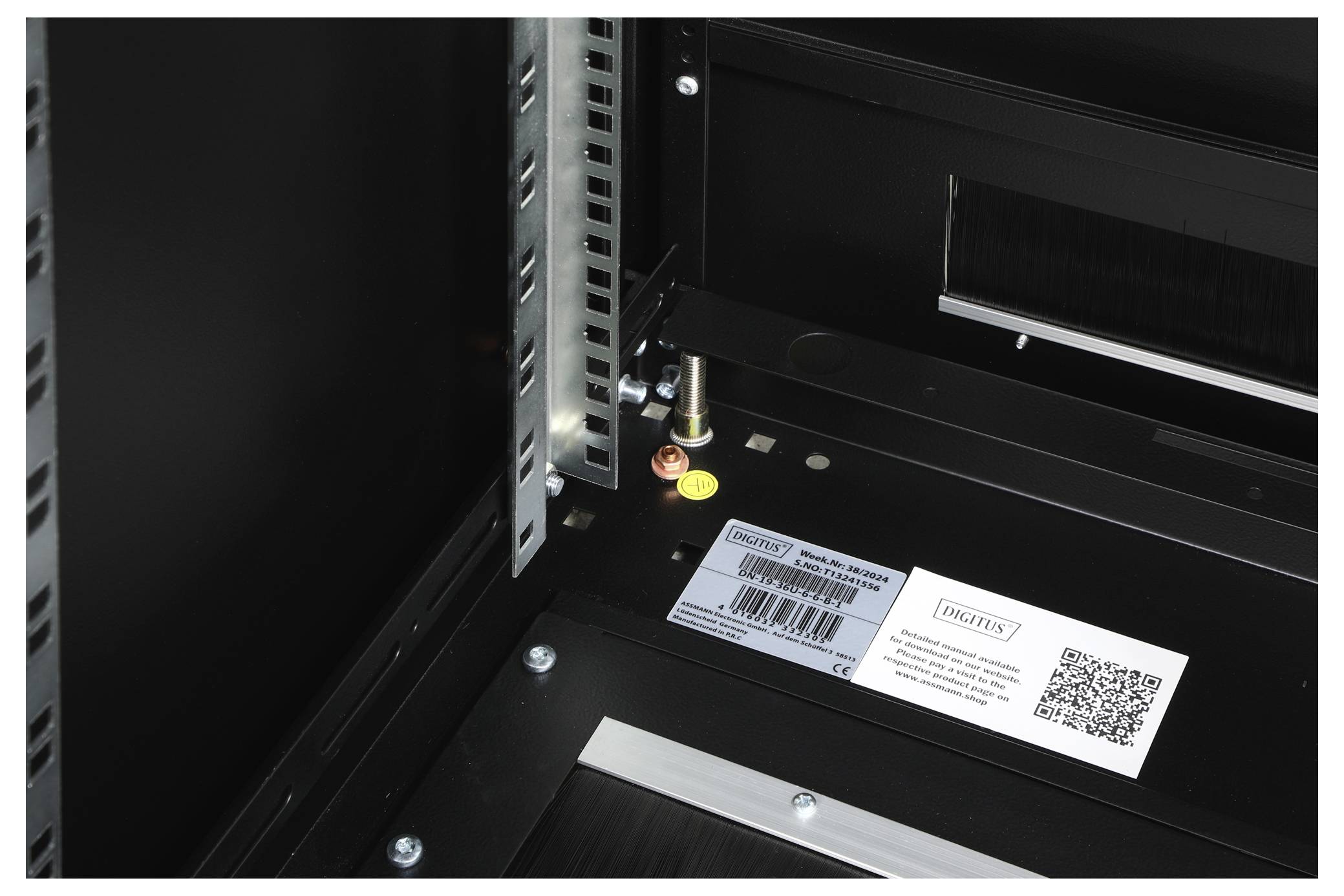 Ein Servergehäuse mit montierter Haltevorrichtung und Etikett mit Barcode und QR-Code. Metalldetails und Innenansicht sind sichtbar.