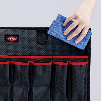 Eine Hand legt ein blaues Mikrofasertuch in eine schwarze Werkzeugtasche mit roten Akzenten. Das Knipex-Logo ist sichtbar.