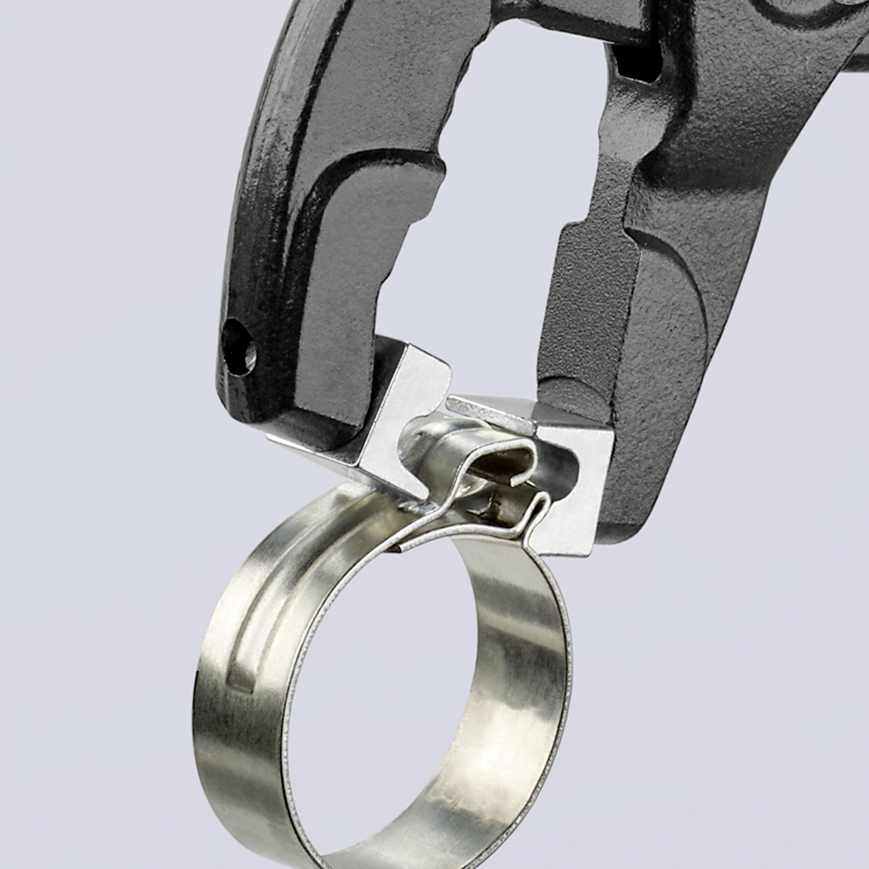 Ein schwarzer Gegenstand mit einer silbernen Metalloberfläche, der wie ein Spezialwerkzeug aussieht, ist mit einem Metallring verbunden.