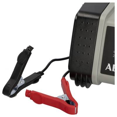 Ein Batterieladegerät mit angebrachten schwarzen und roten Krokodilklemmen, das zum Aufladen von Autobatterien verwendet wird.
