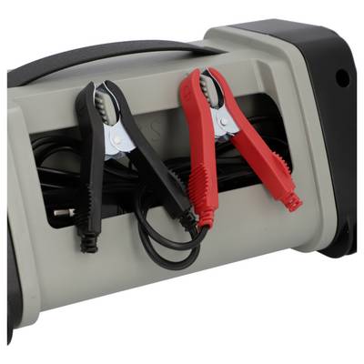 Eine graue Starthilfegerät mit angeschlossenen roten und schwarzen Krokodilklemmen zum Aufladen von Autobatterien.