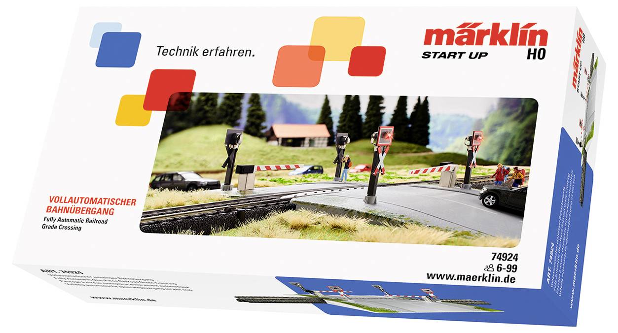 Verpackung einer Modelleisenbahn mit vollautomatischem Bahnübergang von Märklin START UP. Zeigt Schienen mit Signalen und Schranken.