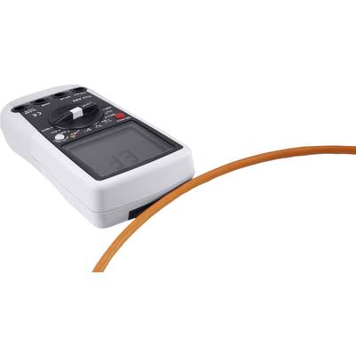 Ein Multimeter neben einem orangenen Kabel, das Messungen durchführt.