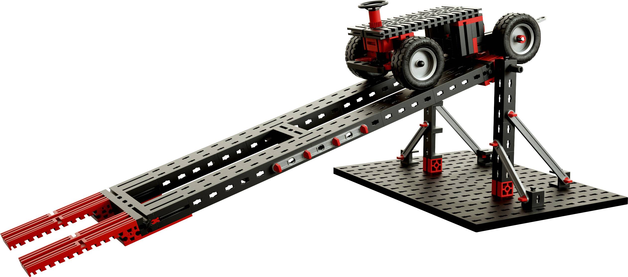 Ein Modellbau-Rennwagen steht auf einer geneigten Rampe aus Metallteilen und Rädern. Das Setup wirkt wie ein Experimentiergerät.