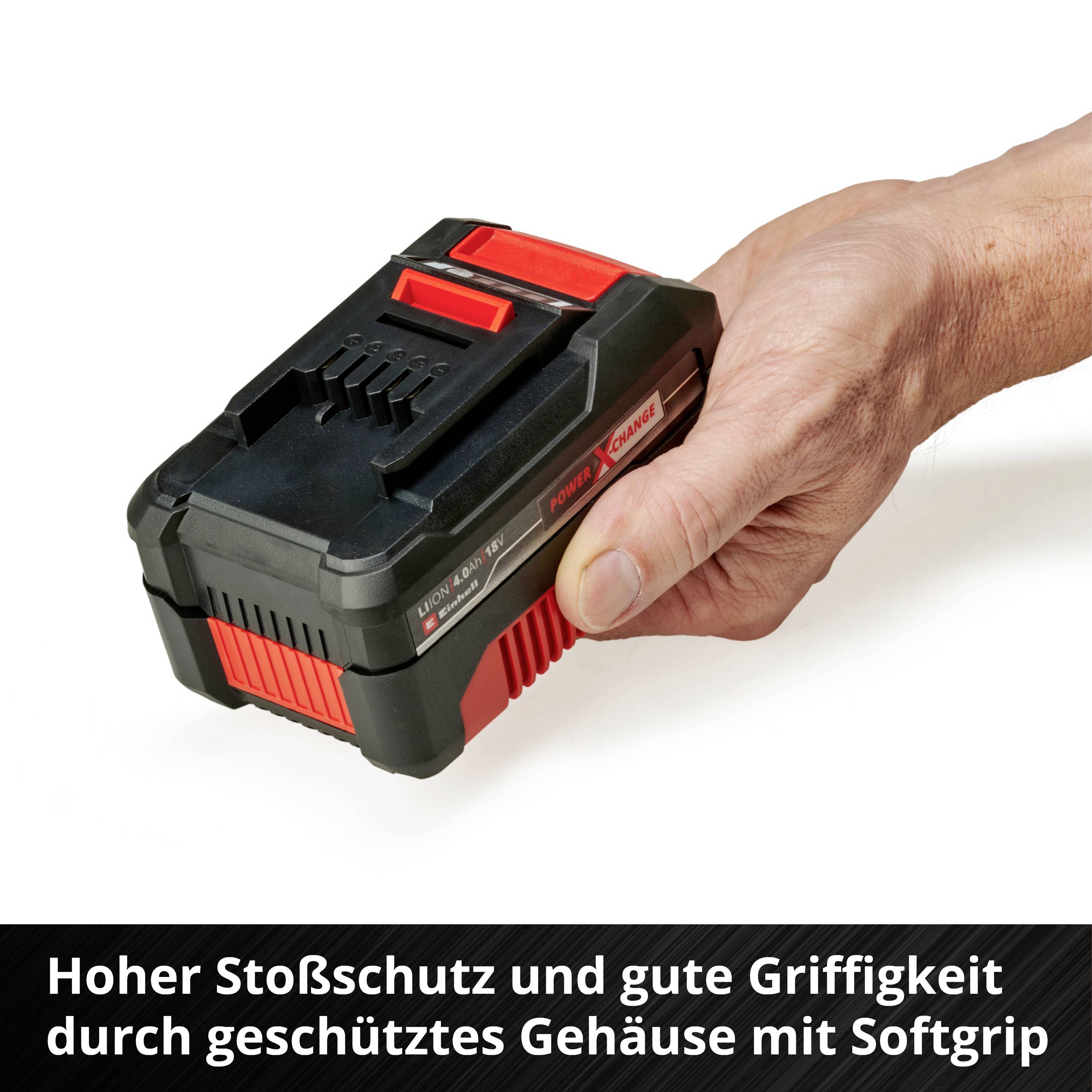 Ein rechteckiger Akku mit rotem und schwarzem Gehäuse wird von einer Hand gehalten. Der Akku bietet Stoßschutz und Softgrip.