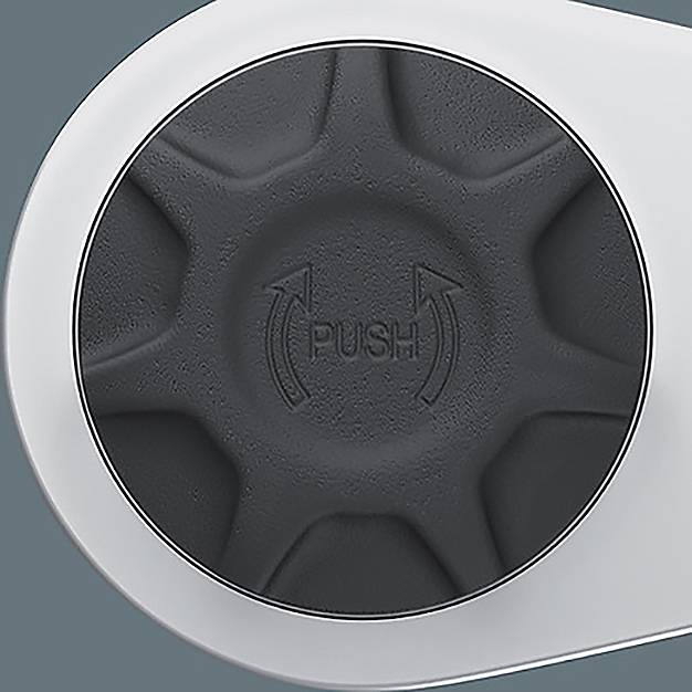 Ein kreisförmiger schwarzer Knopf mit der Beschriftung ‚PUSH', versehen mit Pfeilen, die einen Drehvorgang andeuten, vor einem hellgrauen Hintergrund.