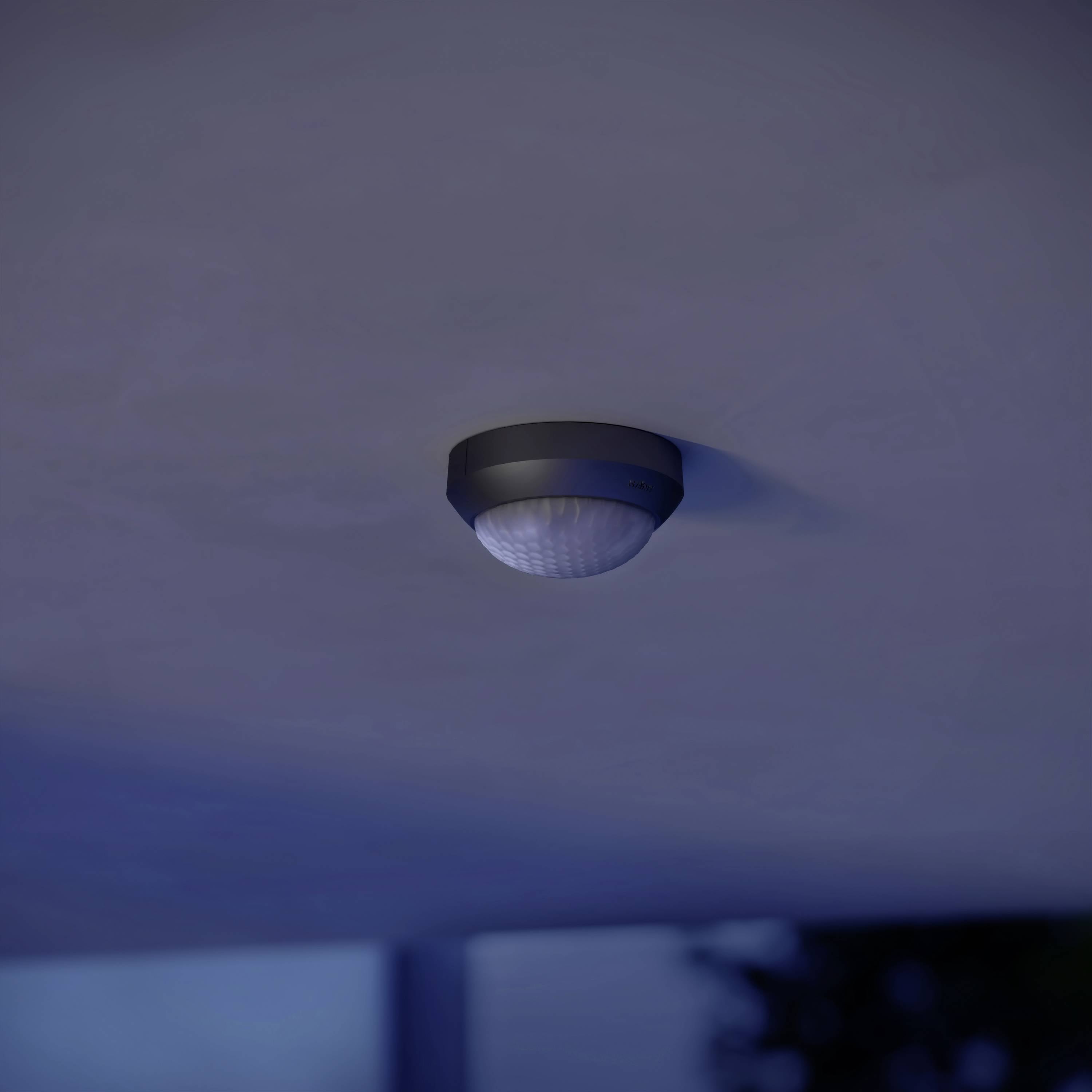 Deckenleuchte mit Bewegungssensor leuchtet schwach in der Dunkelheit. Befindet sich an der Decke in einem Außenbereich.