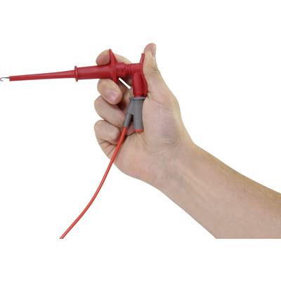 Eine Hand hält eine rote Prüfspitze mit einem Kabel, das für elektrische Messungen verwendet wird.