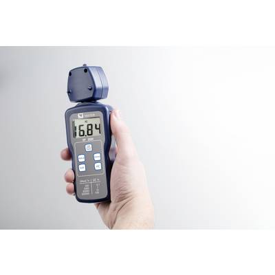 Eine Hand hält ein digitales Anemometer, das eine Anzeige von 16,84 zeigt. Das Gerät misst Windgeschwindigkeit und Temperatur.
