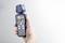 Eine Hand hält ein digitales Anemometer, das eine Anzeige von 16,84 zeigt. Das Gerät misst Windgeschwindigkeit und Temperatur.