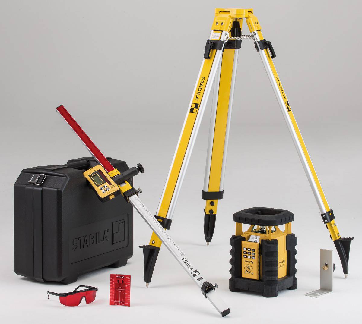 Baustellen-Lasergerät-Set mit Stativ, Empfänger, Maßstab, Schutzbrille und Transportkoffer auf grauem Hintergrund.