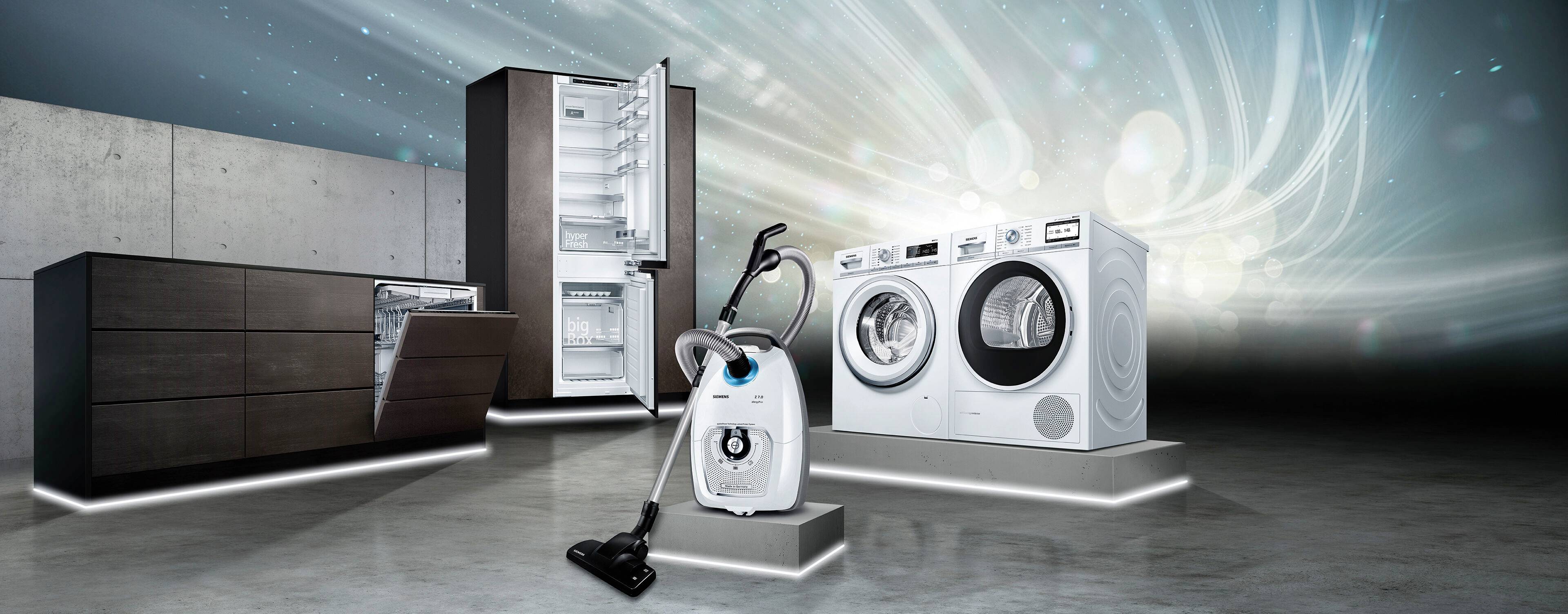 Ein moderner Küchen- und Haushaltsgeräte-Showroom zeigt einen Kühlschrank, eine Spülmaschine, eine Waschmaschine und einen Staubsauger.