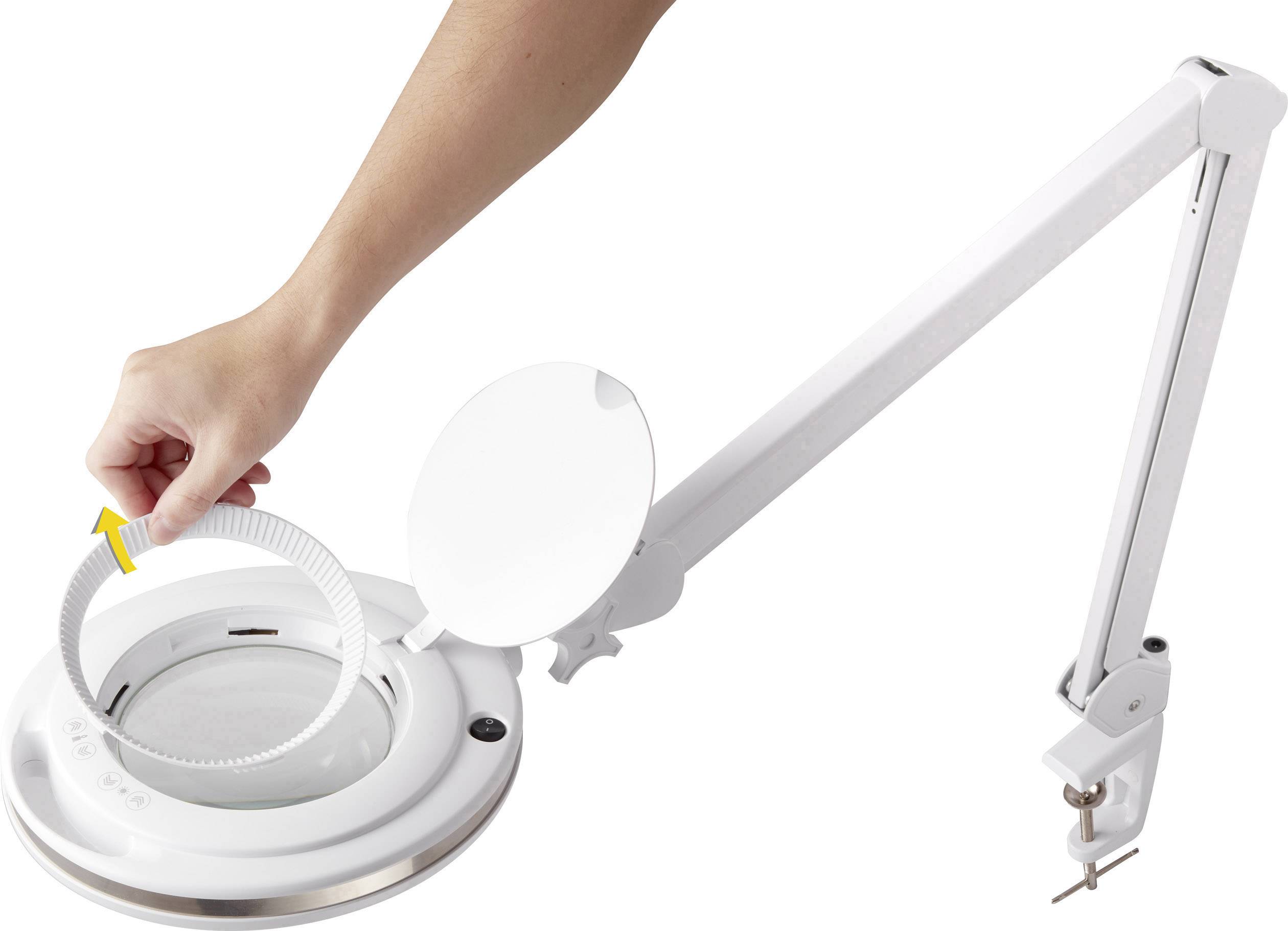 Ein verstellbarer, weißer Vergrößerungsarm mit Lampe, an dem eine Person einen Ring mit einer gelben Markierung einsetzt.
