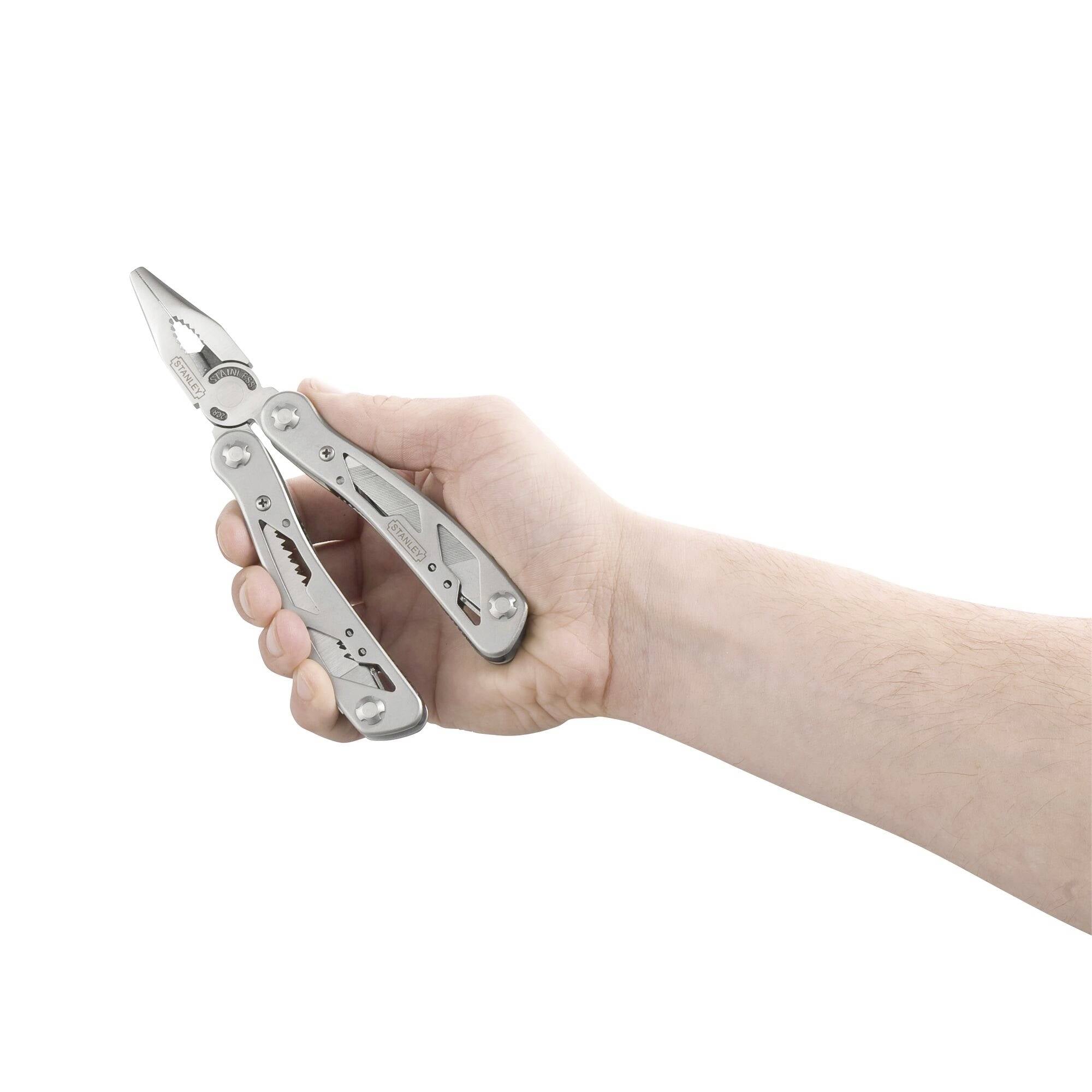 Eine Hand hält ein geöffnetes Multitool mit einer Zange und mehreren Werkzeugen.