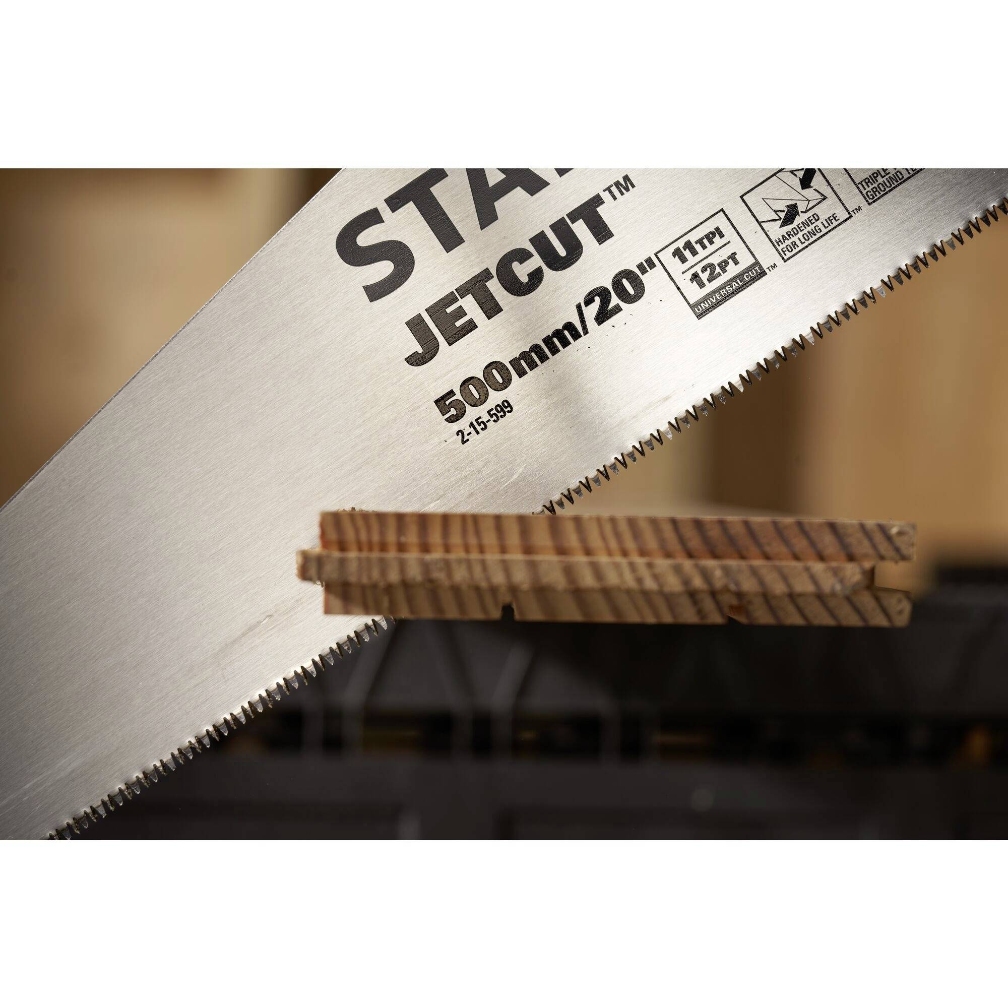 Eine Säge schneidet ein Stück Holz. Auf der Säge steht 'JETCUT' und '500mm/20"'. Das Holz zeigt eine klare, gerade Schnittlinie.