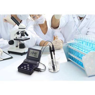 Wissenschaftler arbeiten im Labor mit Mikroskopen und Reagenzgläsern. Im Vordergrund ein pH-Messgerät, das den Wert 13,49 anzeigt.