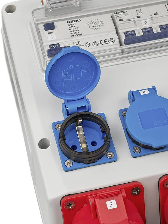 Ein geöffneter blauer Stromanschluss an einer Verteilereinheit, daneben ein geschlossener Anschluss, gekennzeichnet mit Zahlen.