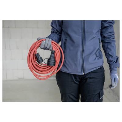 Person in Arbeitskleidung, die ein aufgerolltes rotes Verlängerungskabel mit schwarzen Steckern hält.