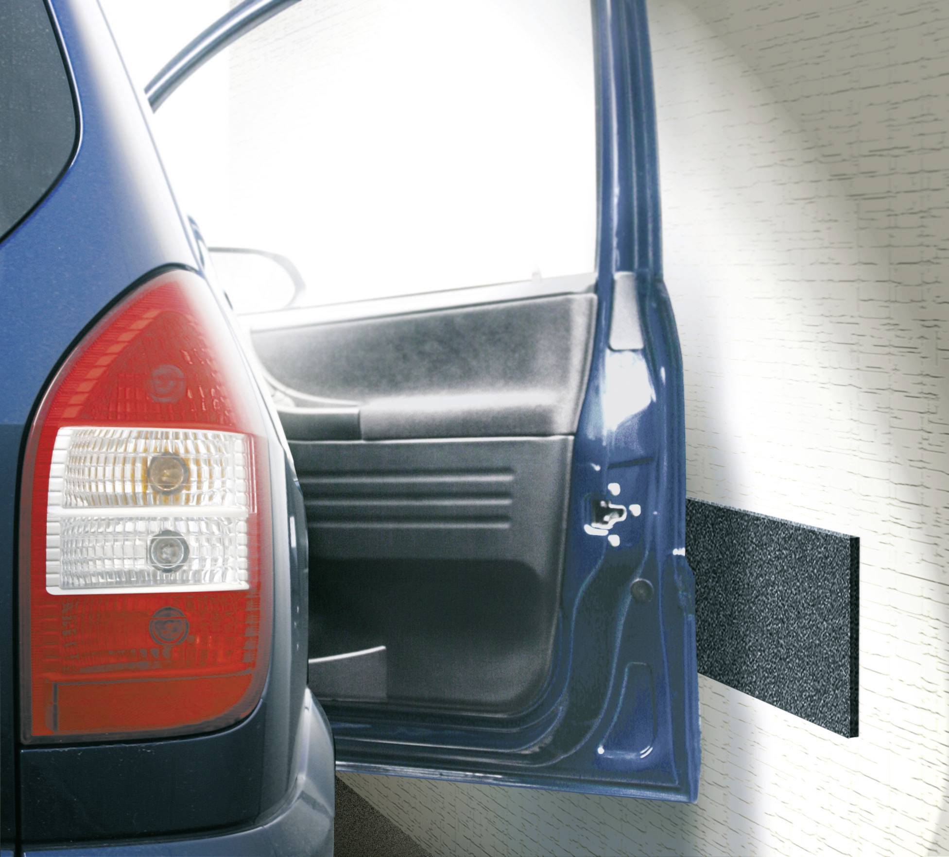 Ein blaues Auto steht in einer Garage. Die Fahrertür ist geöffnet und wird von einem schwarzen Schutzpolster an der Wand geschützt.