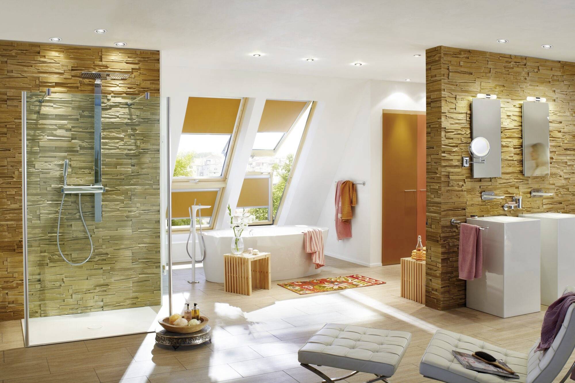 Modernes Badezimmer mit gläserner Duschkabine, zwei Waschbecken und großen Fenstern. Helle Wände und Holzelemente sorgen für ein warmes Ambiente.