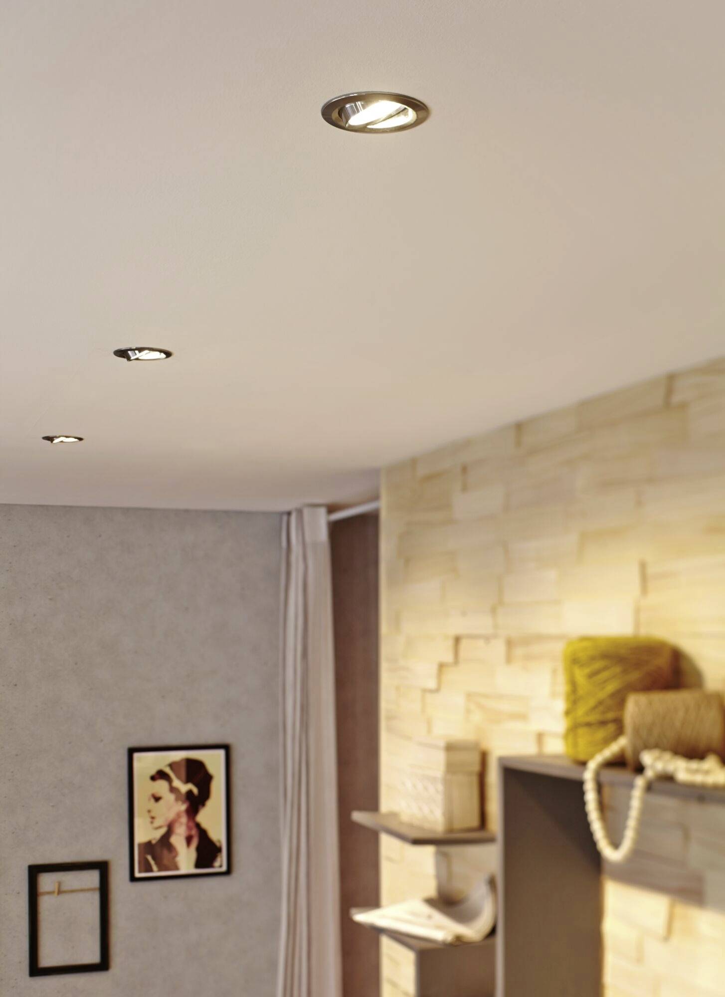 Wohnzimmer mit gemütlicher Beleuchtung, Holzwand, Regalen mit Dekor und einem gerahmten Bild an der Wand.