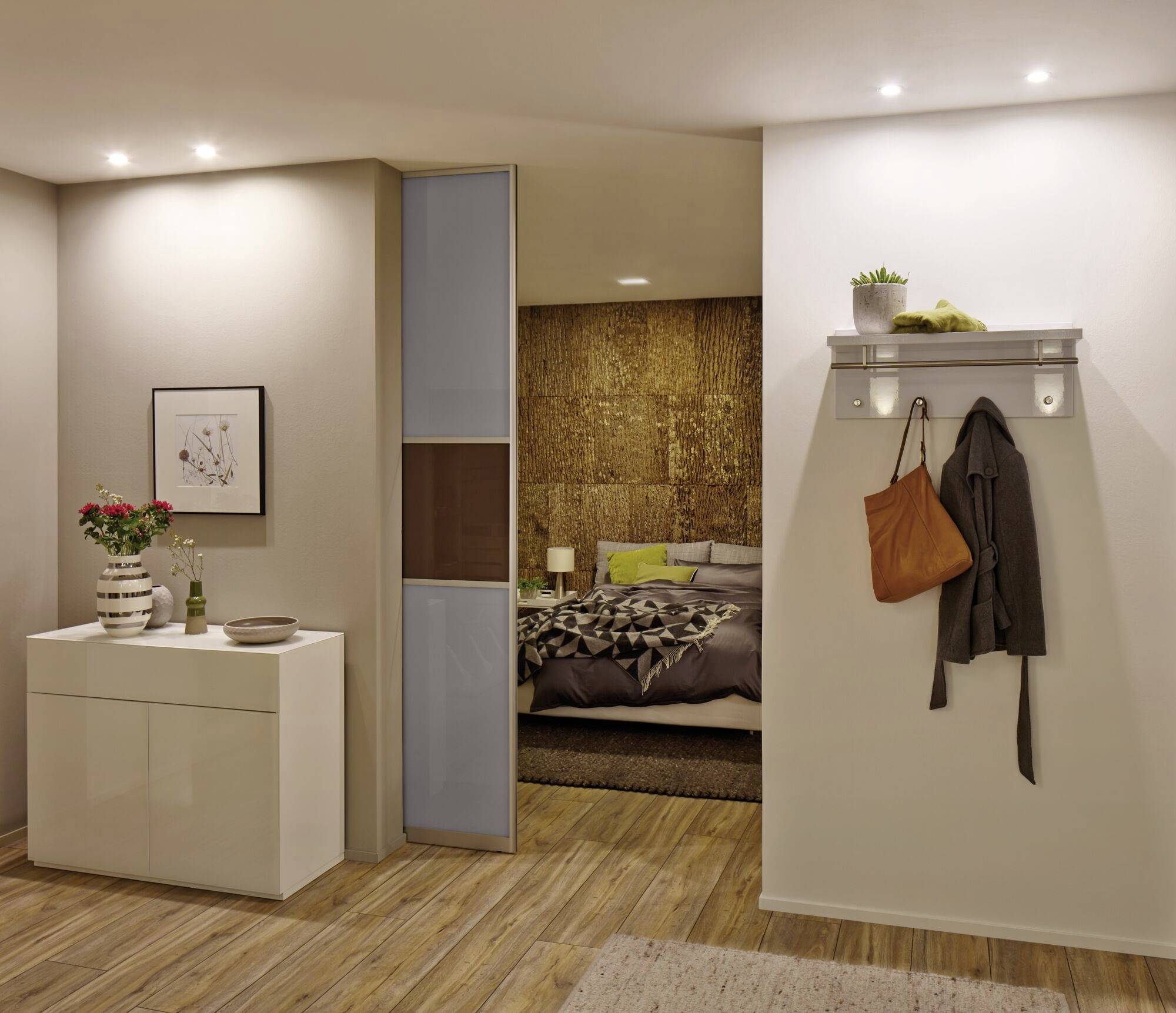 Moderner Eingangsbereich mit weißem Schrank, Gemälde an der Wand, und Blick ins gemütliche Schlafzimmer mit Holzdetails.