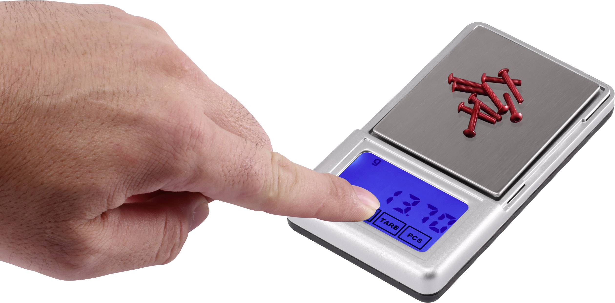 Eine elektronische Waage zeigt ein Gewicht von 137 g an, während rote Schrauben darauf liegen. Eine Hand drückt eine Taste der Waage.
