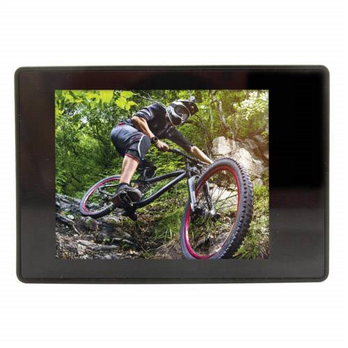 Eine Person auf einem Mountainbike fährt einen steilen, kurvigen Waldpfad bergab. Sie trägt Schutzkleidung und Helm, umgeben von dichtem Grün.