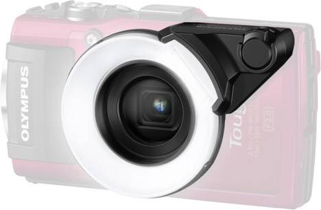 Eine rote Olympus-Kamera mit großem Ringblitz, geeignet für Nahaufnahmen. Die Kamera ist teilweise im Hintergrund sichtbar.