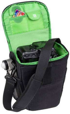 Kameratasche mit offenem Deckel zeigt Kamera und Speicherkarte im Inneren. Schwarze Außenseite, grün gefütterter Innenbereich.