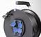 Schwarze Kabeltrommel mit blauem Schutzabdeckungen und Kabel versehen. Ein ausziehbarer Griff ist an der Oberseite zu sehen.