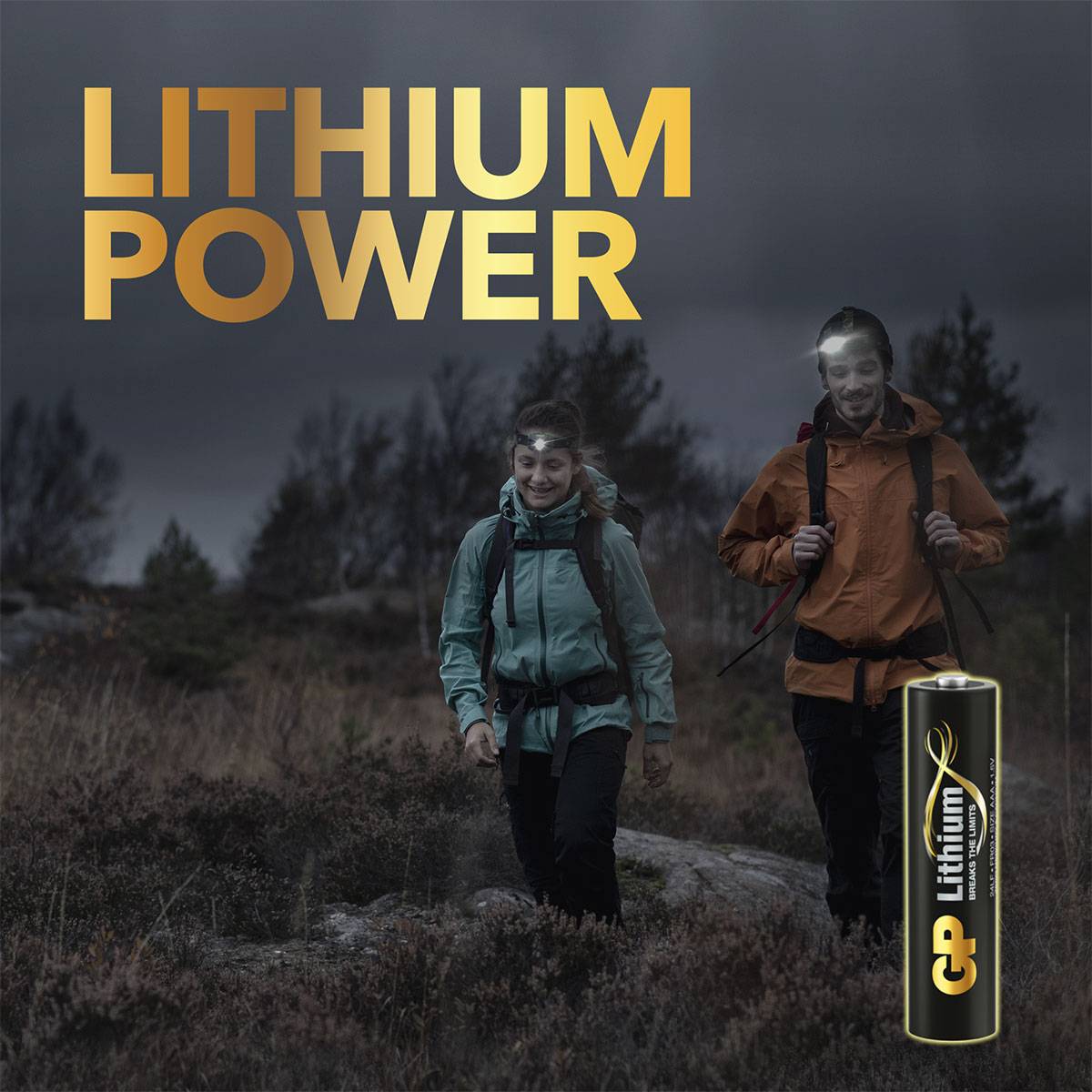 Zwei Personen wandern im Wald unter bewölktem Himmel, neben ihnen steht der Text 'LITHIUM POWER' und eine AA-Batterie von GP.