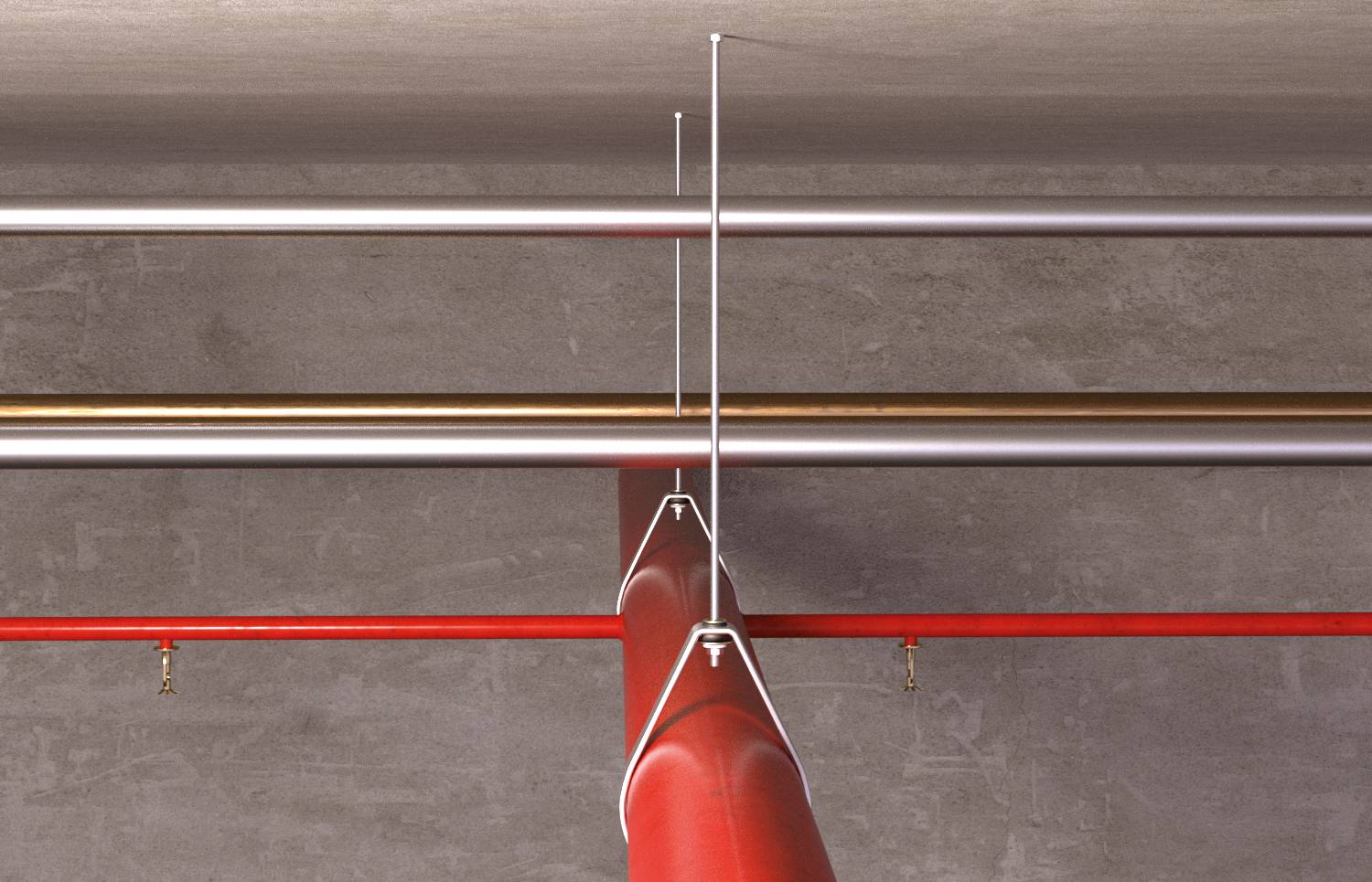 Rote Sprinklerleitung mit zwei silbernen Rohren und einem roten horizontalen Abzweig gegen eine Betondecke.