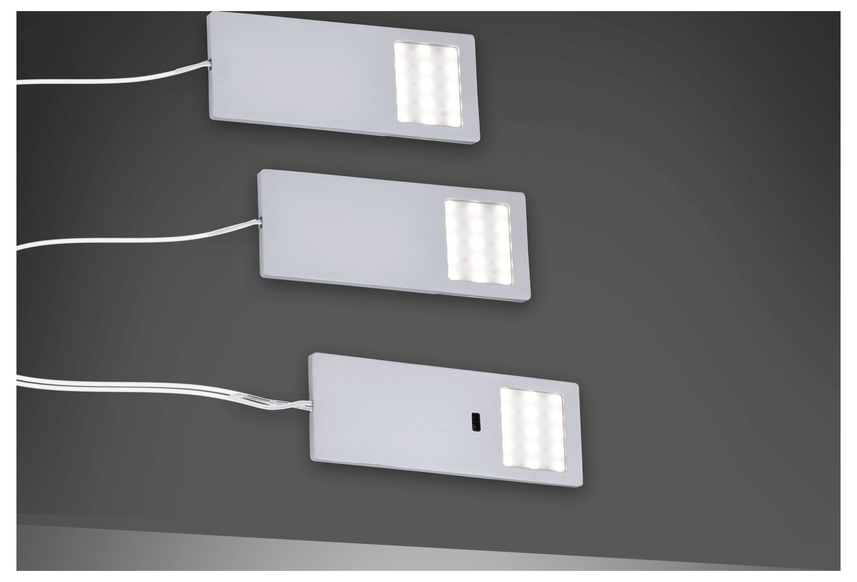 Drei längliche LED-Leuchten mit weißen Kabeln, horizontal auf dunklem Hintergrund ausgerichtet.