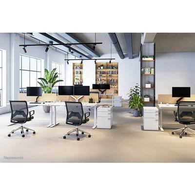 Modernes Büro mit mehreren Schreibtischen, Bürostühlen und Monitoren, helle Beleuchtung, Pflanzen in Ecken, Regale an der Rückwand.