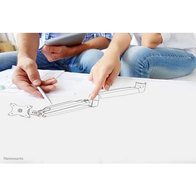 Zwei Personen diskutieren ein technisches Design auf einem Papier. Eine Person zeigt darauf, während die andere eine Zeichnung hält.