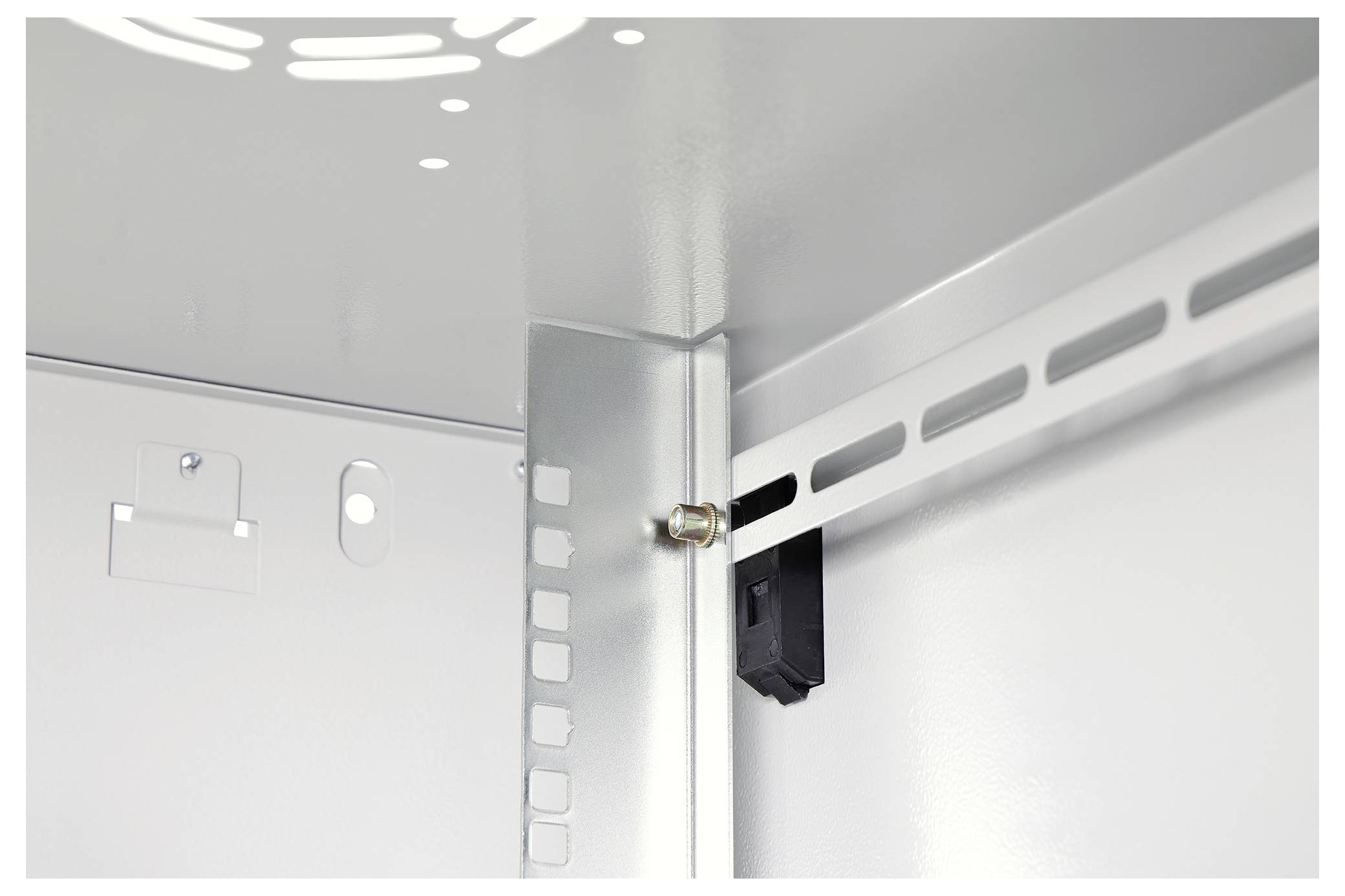 Innere Ecke eines Metallgehäuses, die einen vertikalen Stützträger mit Schlitzlöchern und einem nahe der Oberseite angebrachten Bolzen zeigt.