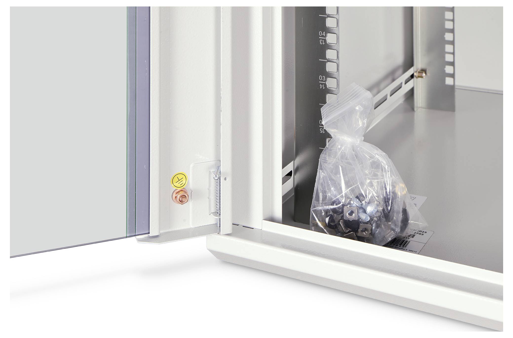 Ein elektrischer Schaltschrank geöffnet mit einem transparenten Beutel, der Schrauben im Inneren enthält.