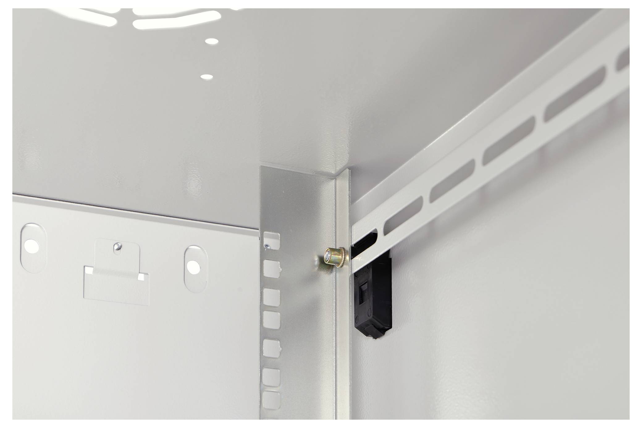 Innenansicht eines Metallschaltschranks, der Montagebeschläge und einen geschlitzten Metallhalter zeigt, der mit einem Bolzen befestigt ist.