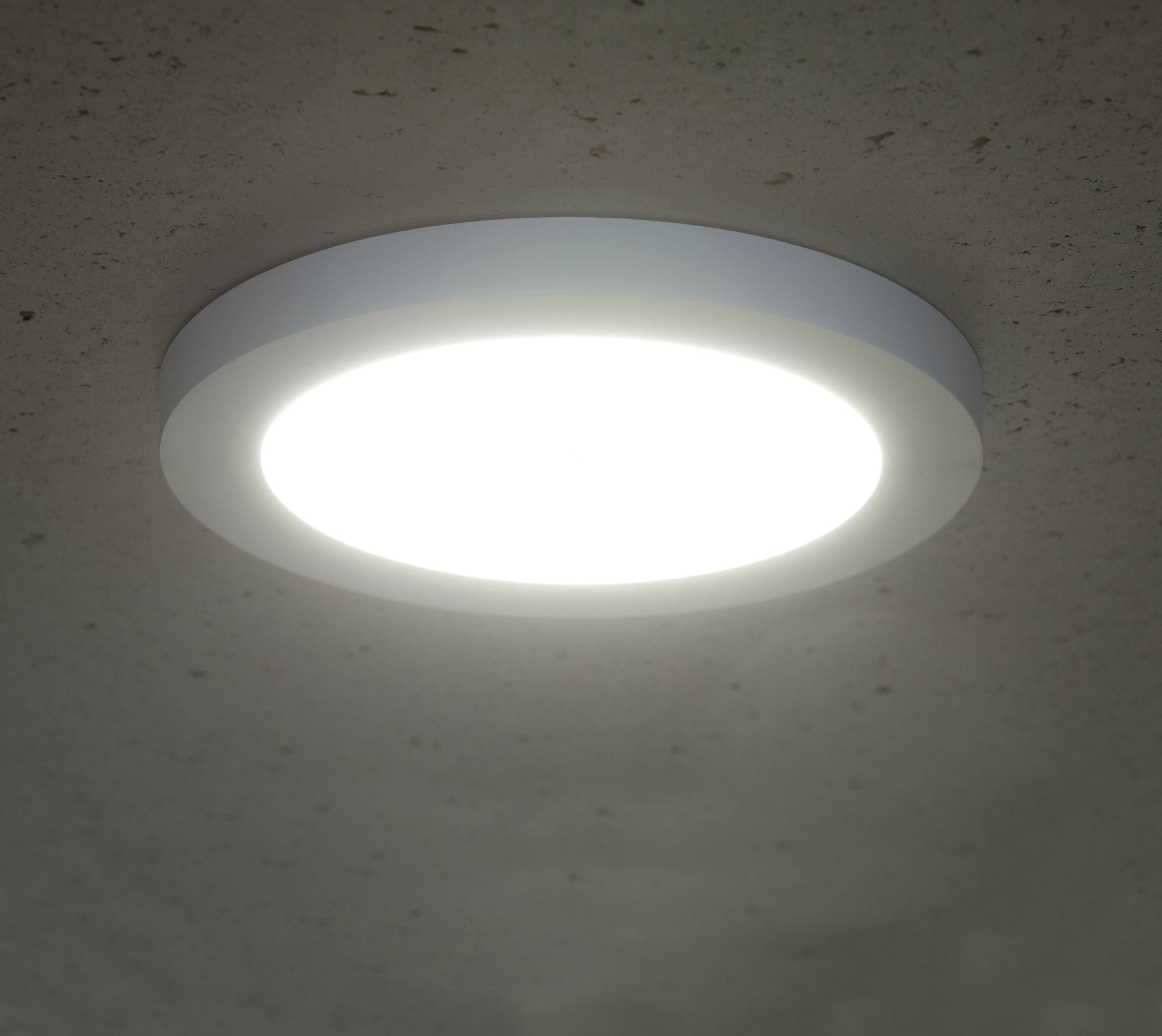 Eine runde, helle Deckenleuchte, die an einer weißen Decke befestigt ist, strahlt gleichmäßig Licht aus.