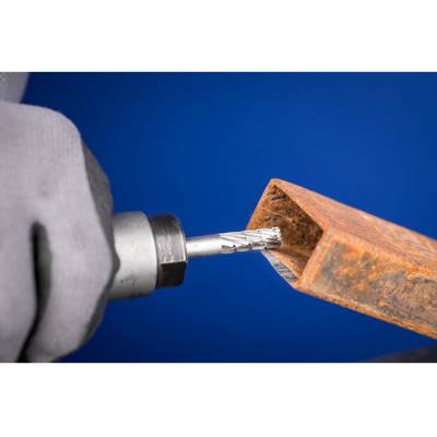 Eine behandschuhte Hand hält eine Bohrmaschine, die ein rostiges Metallstück bearbeitet, vor einem blauen Hintergrund.