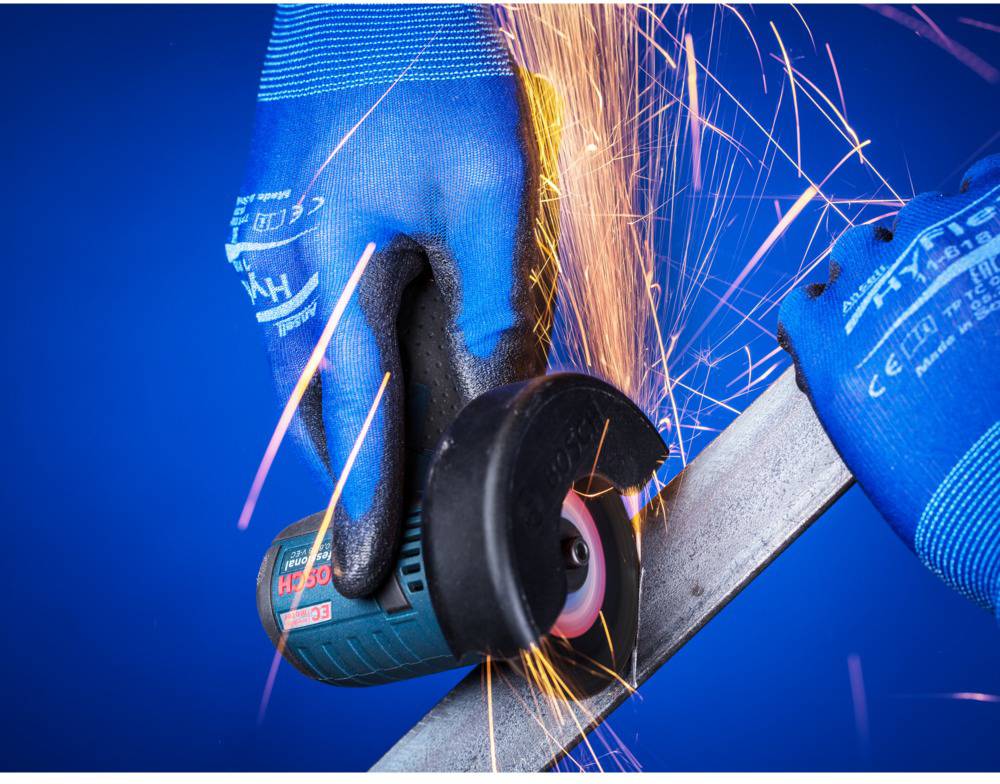 Person mit blauer Arbeitshandschuh bearbeitet Metall mit einem Winkelschleifer, Funken fliegen.