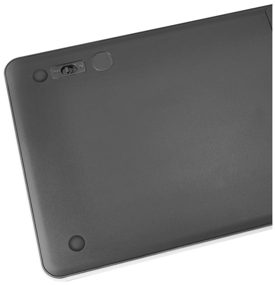 Rückseite eines elektronischen Geräts mit Batteriefach und vier runden Gummifüßen in den Ecken.