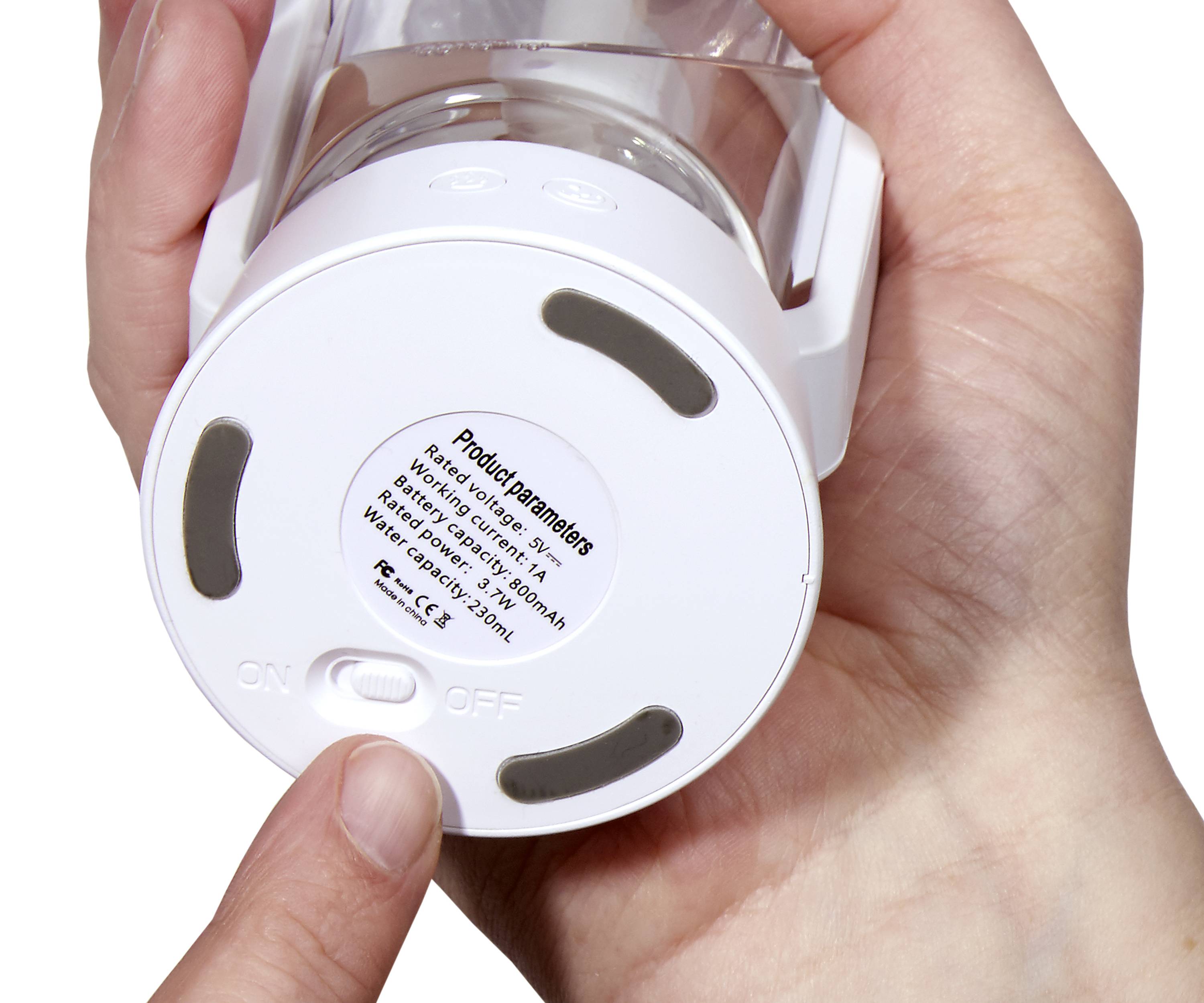 Nahaufnahme einer Hand, die die Basis eines weißen Geräts mit der Aufschrift 'Product Parameters' berührt, der Schalter ist auf 'ON'.