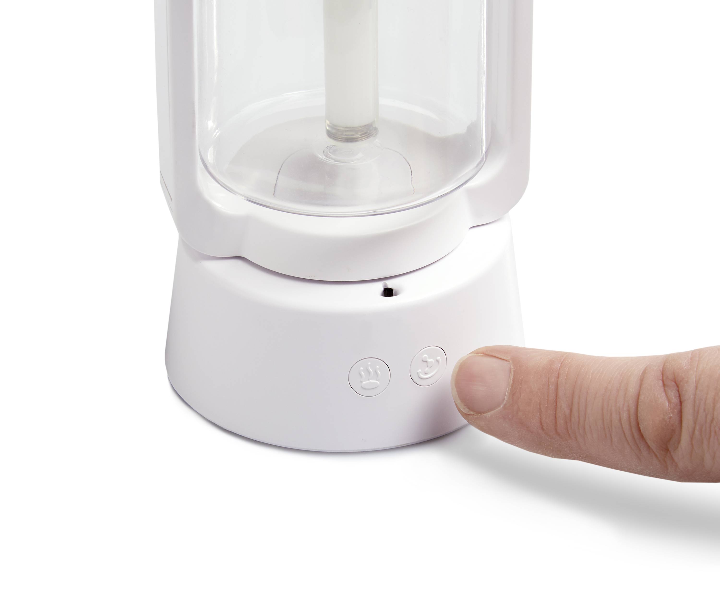 Eine Hand drückt den Einschaltknopf an einem weißen Haushaltsgerät mit zwei sichtbaren Symbolen auf der Vorderseite.