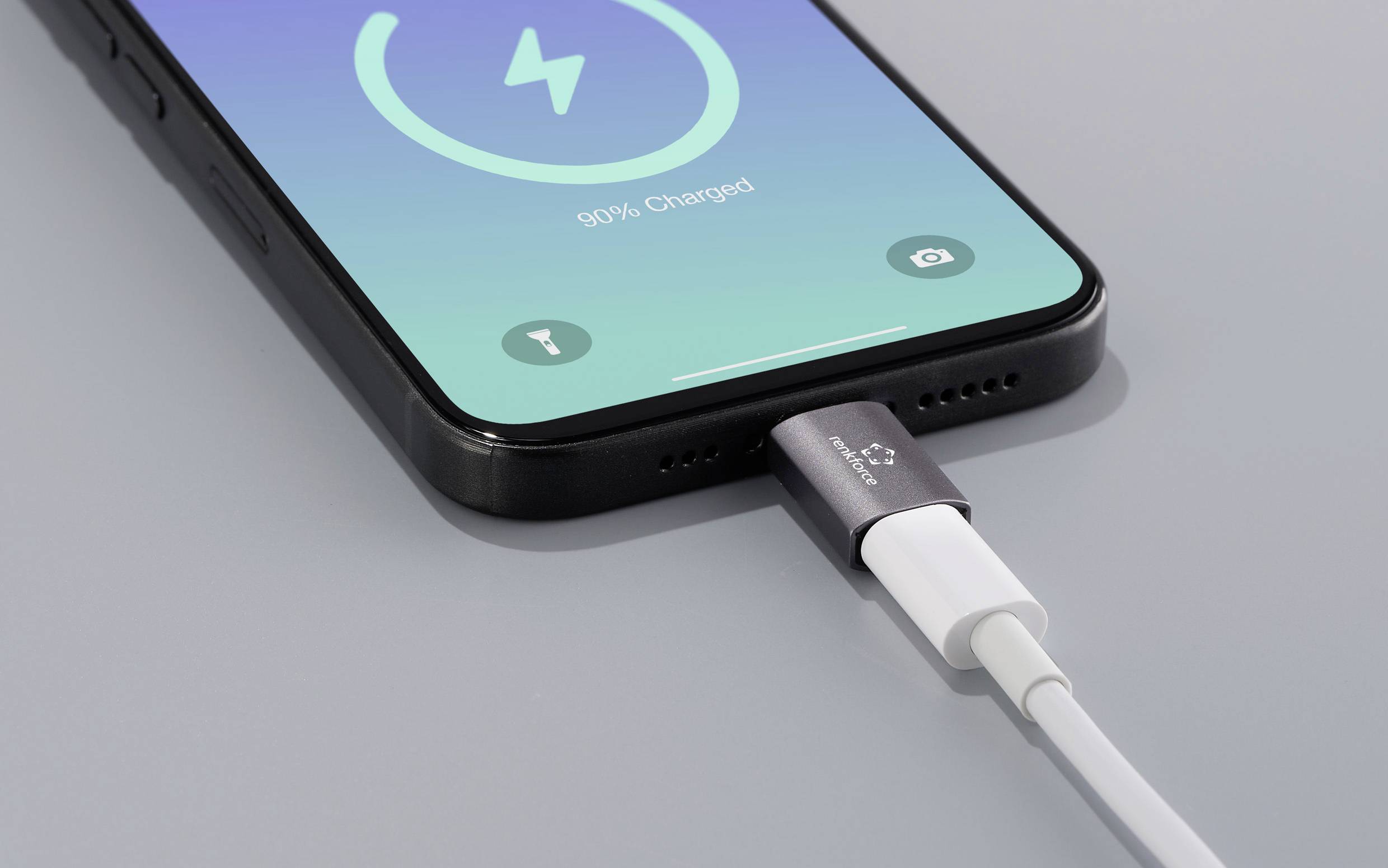 Ein Smartphone wird mit einem Kabel aufgeladen. Der Bildschirm zeigt '90% aufgeladen' an, mit einem Lade-Symbol oben.