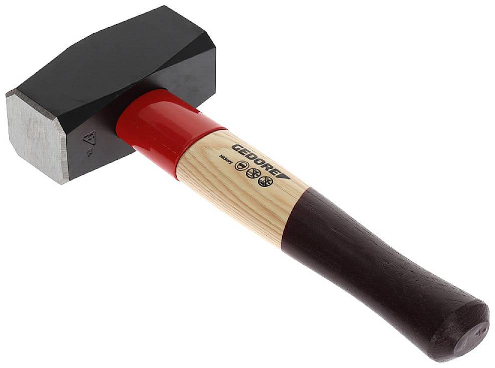 Ein Hammer mit hölzernem Griff und schwarz-rotem Kopf, Marke 'GEDORE', liegt schräg.