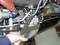 Eine Person repariert Motor eines Flugzeugs mit einem Schraubenschlüssel. Fokus liegt auf der Hand und dem Werkzeug am Metallteil.
