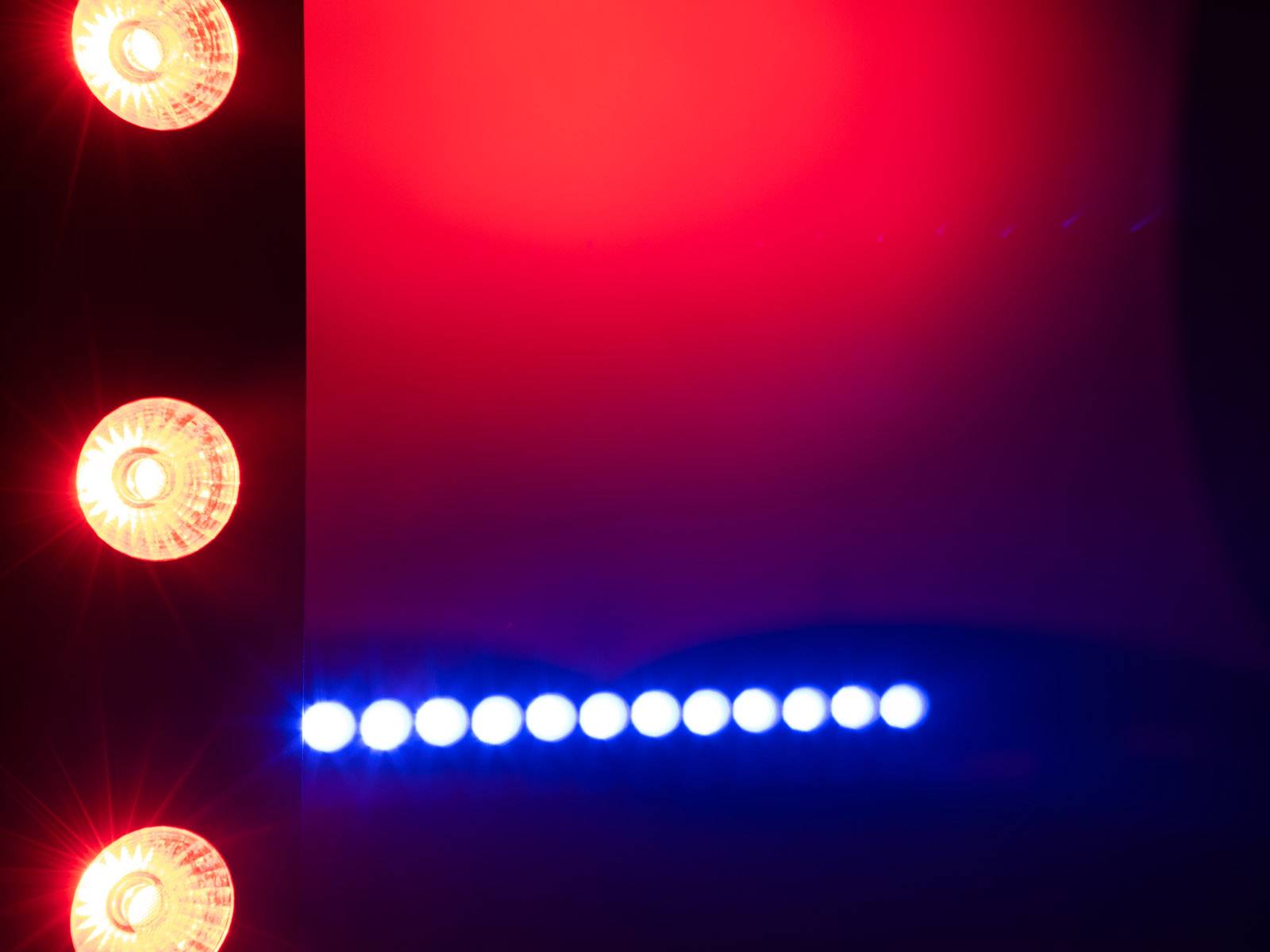 'Rote und blaue Lichter'; rote Lichter an der Seite einer Oberfläche, blaue Lichter in einer geraden Linie darunter; möglicherweise Lichteffekte.